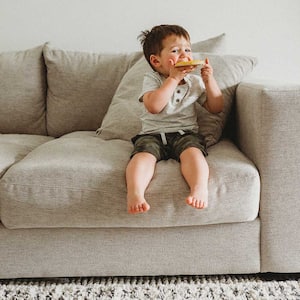 Boy sitting on the sofa eating a snack
