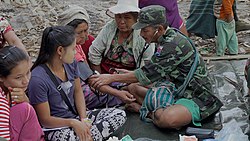 KNLA medic treating displaced civilians (Steve Sandford-VOA).jpg