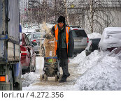 Дворник - гастарбайтер посыпает тротуар реагентами, Новокосинская улица, район Новокосино, Москва (2013 год). Редакционное фото, фотограф lana1501 / Фотобанк Лори