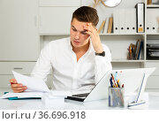 european guy in white shirt puzzled by problems in office. Стоковое фото, фотограф Татьяна Яцевич / Фотобанк Лори