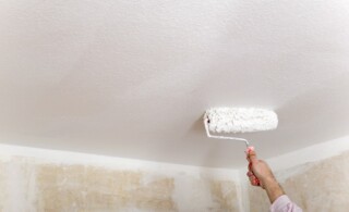 roller painting a popcorn ceiling