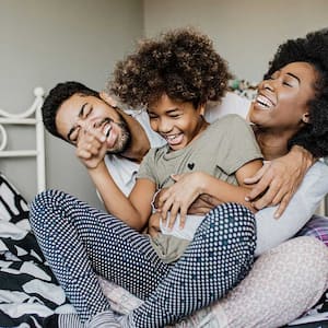 Family playing on bed