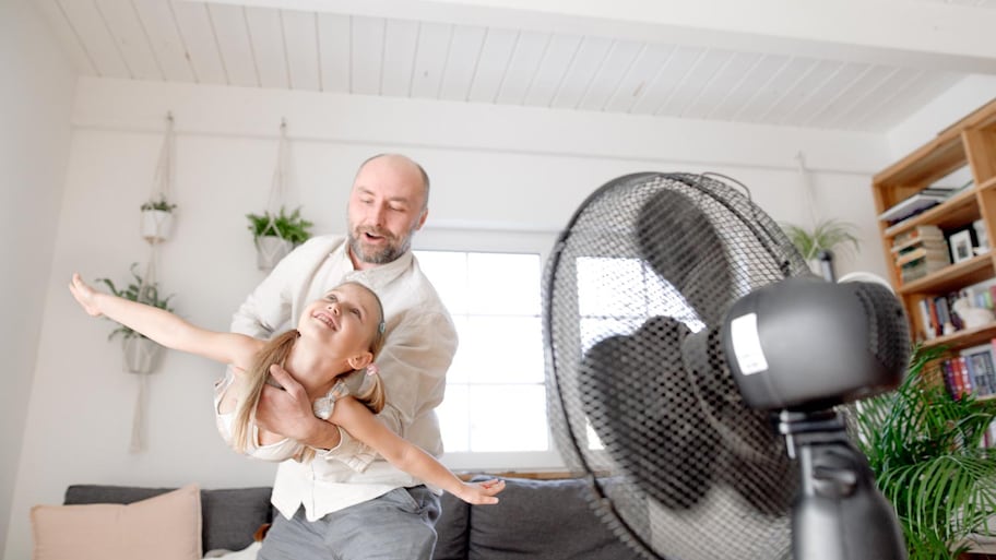 Father having fun with daughter imitating airplane at home