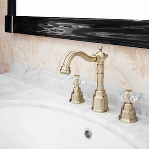 closeup of gold bathroom faucet on marble countertop with white sink