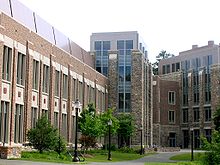 A four-story brick and stone building alongside pedestrian path