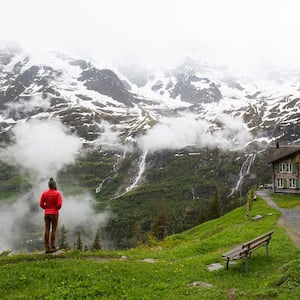 Woman wearing a red jacket hiking and enjoying the view