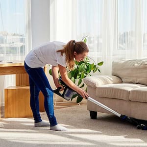 Woman vacuuming and cleaning living room