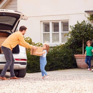 A family unloading boxes from the car on moving day