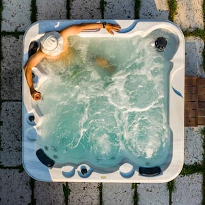 Man in hot tub stones grass overhead