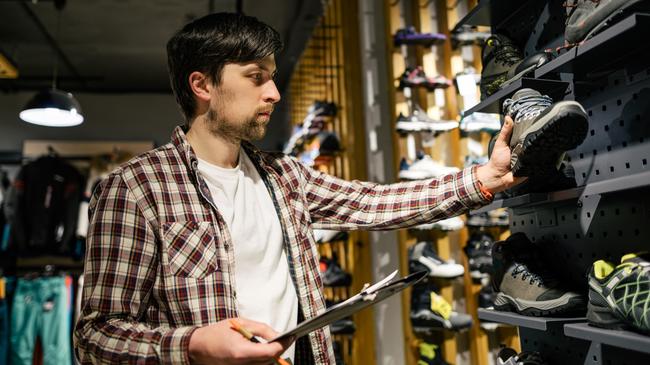 man with a shoe in his hand writing the reference