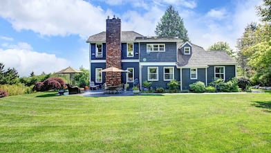 Blue house with chimney and big yard