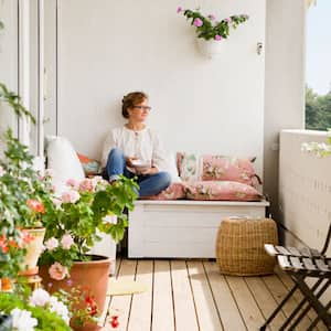 Woman relaxing on balcony with plants