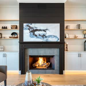 Luxury living room with black shiplap fireplace with abstract gray painting in front of white built-ins with wood shelves 