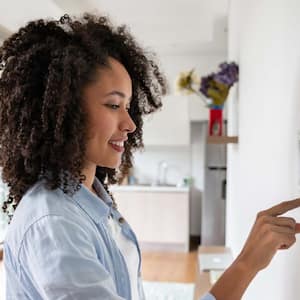 A woman setting up the intelligent home system on a tablet