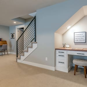 Basement room with home office desk underneath the stairs
