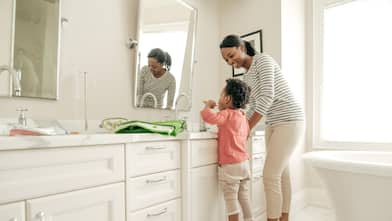 A mother with her daughter brushing her teeth