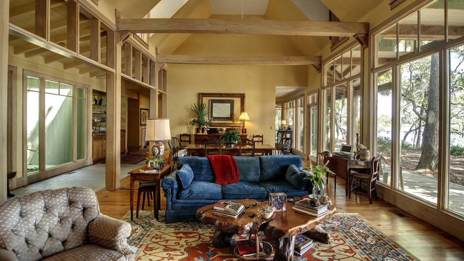 A living room with vaulted ceiling and large windows