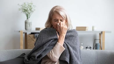 Woman sneezing holding napkin blow out runny nose