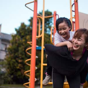 A mother with her daughter playing in the playground