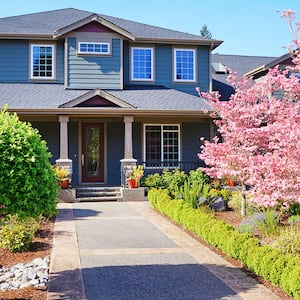 grey large house with beautiful landscaping  