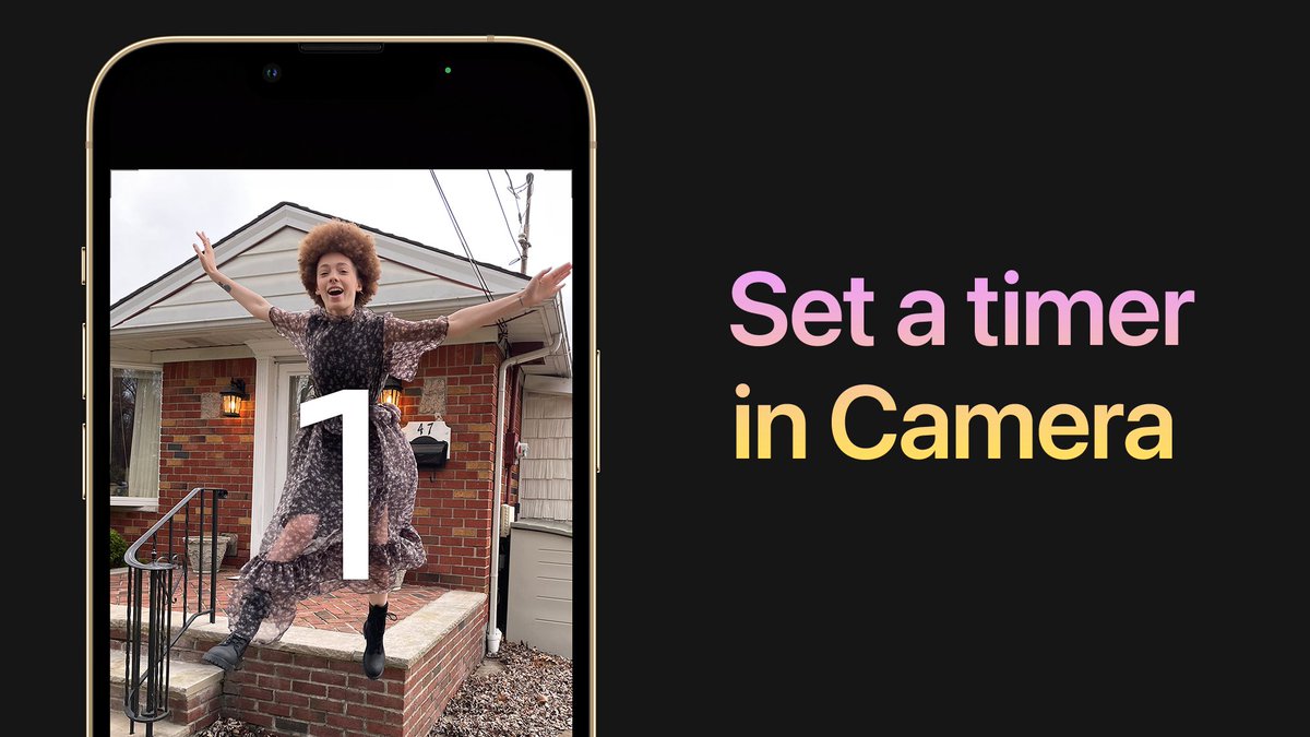 How to set a timer in the Camera app. Camera is open on iPhone with someone in the viewfinder jumping off of the front porch of a house. There is a countdown in the viewfinder at one second before it takes the photo.