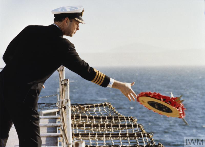 A naval officer laying a wreath into the water during a memorial service held on board the Cunard liner COUNTESS to those killed in the Falklands War.