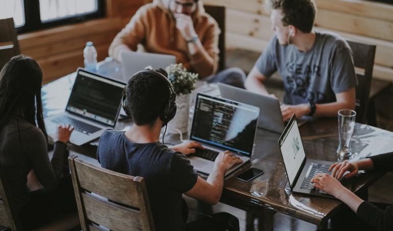 People with laptops sitting around a table