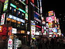 Illuminated signs above a crowded street in Gangnam