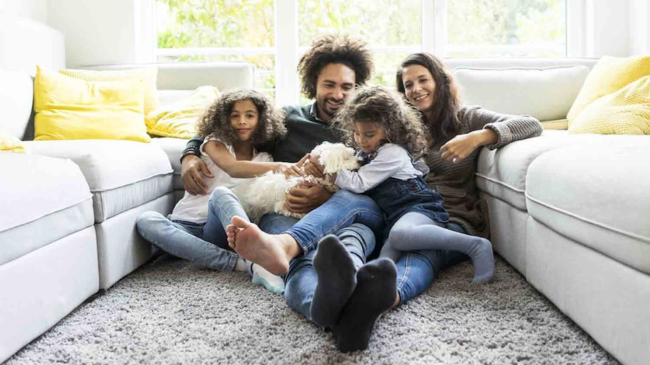 family hanging out sitting on living room carpe