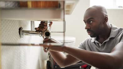 A plumber fixing a bathroom sink