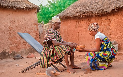 A Dagomba woman serving her husband with water 02.jpg