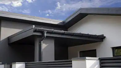 exterior of white home with black accents and gutter system