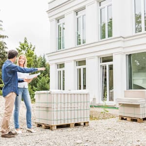 A contractor talking with a client outside her house