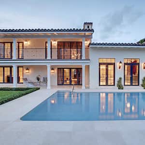 The exterior of a beautiful house with a pool at dusk