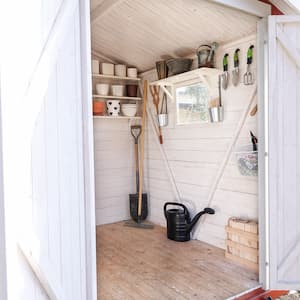 A shed with both doors open with a chair and gardening tools inside