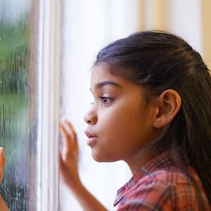 Girl looking out window at storm