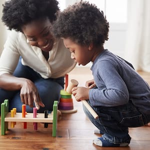 Mother and son playing with toys on floor