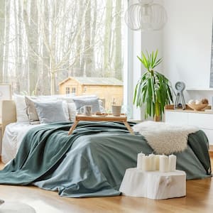 A bedroom interior with a huge window behind the bed