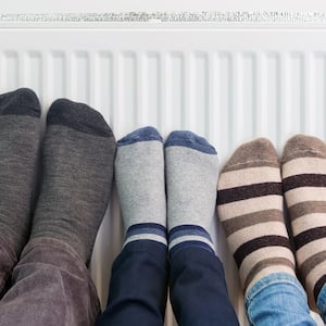 A family warming feet on a radiator