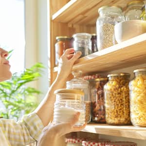 Woman holding a jar of sugar in her pantry