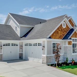 Garage view of home with shingle roof