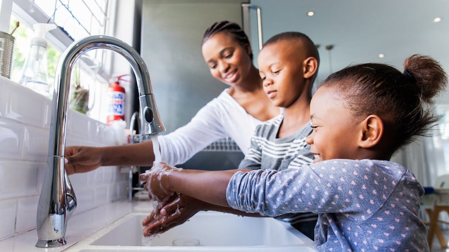 A mother and her children washing their hands together