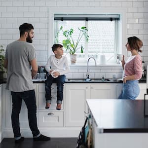 Family hangs out in kitchen with black granite