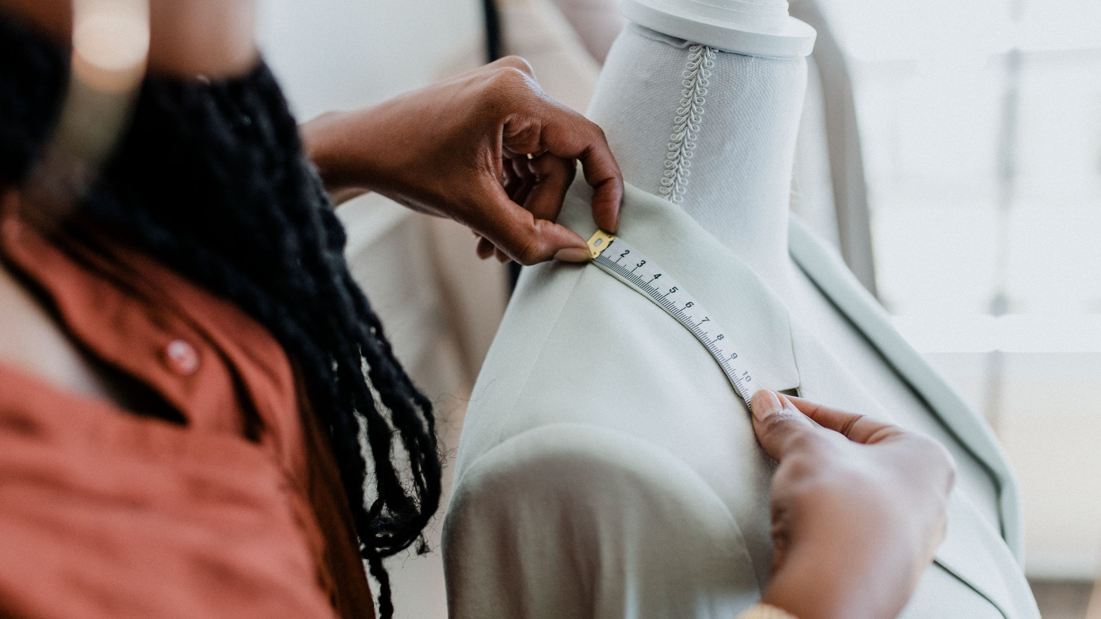 African American fashion designer measuring a garment