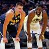 Golden State Warriors' Draymond Green and Denver Nuggets' Nikola Jokic chat in 1st quarter during NBA preseason game at Chase Center in San Francisco, Calif., on Wednesday, October 6, 2021.