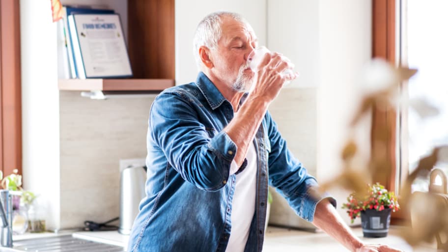 Senior man cooling off with drink of water