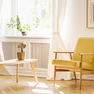 A sunny lounge area of a house with two wooden chairs by the window