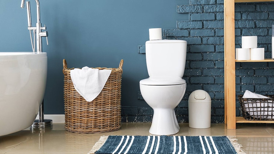 Toilet in bathroom with blue brick walls