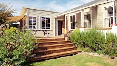 A wooden deck with outdoor furniture in the backyard of a house