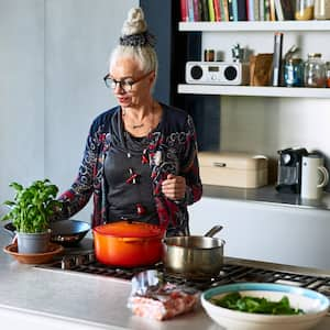 A senior woman preparing dinner in her stylish kitchen